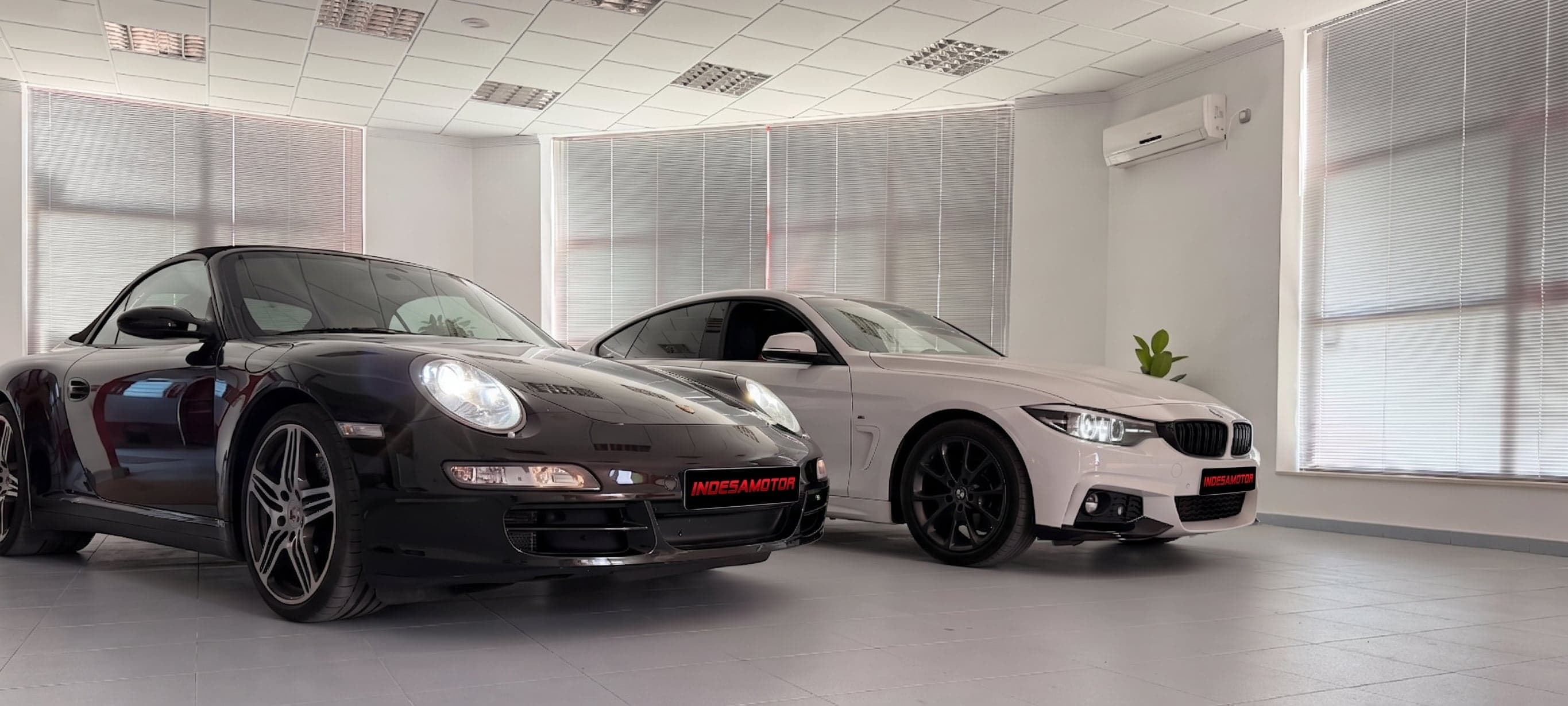 Interior del local de Indesamotor, con un Porsche 911 y un BMW Serie 4